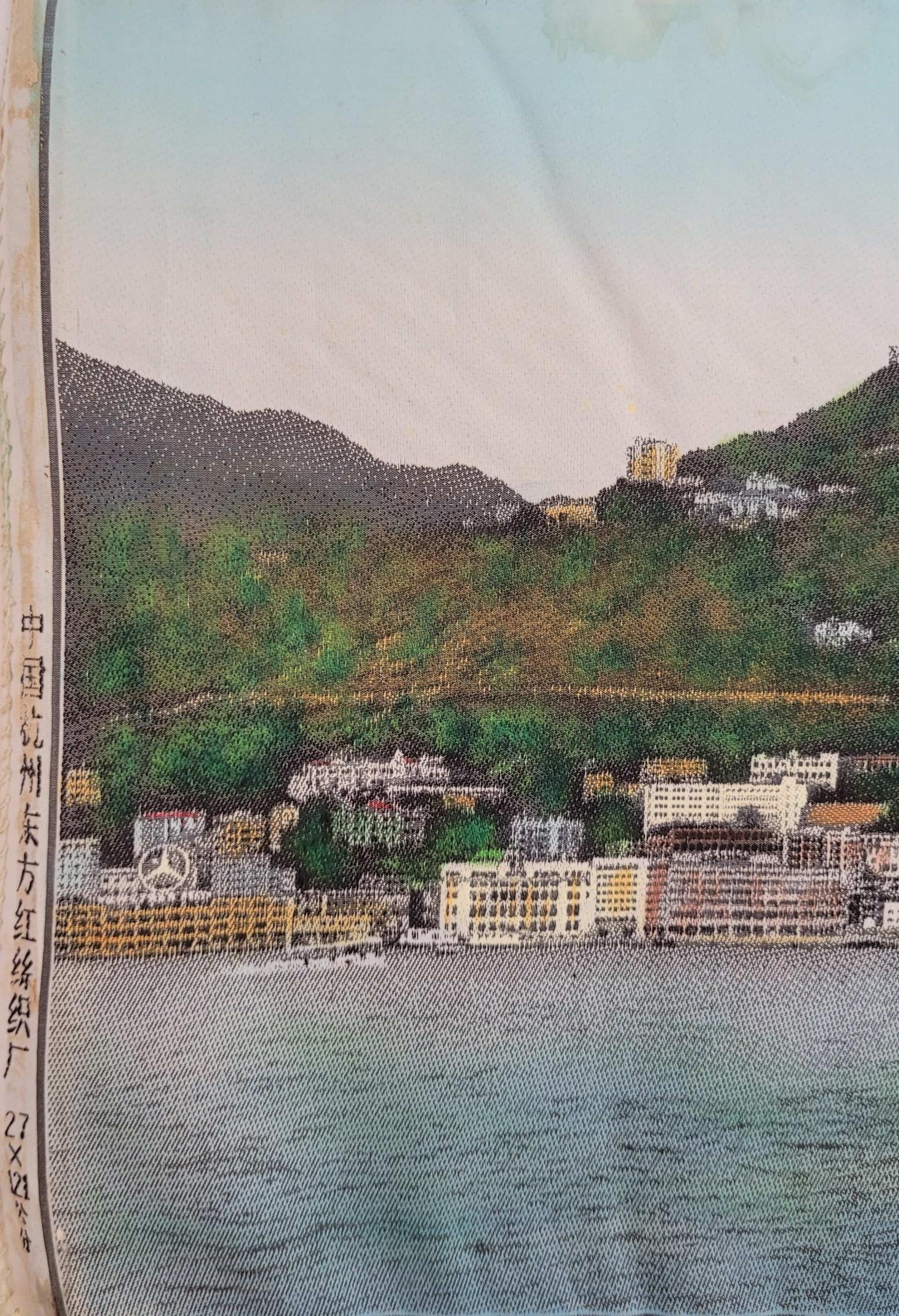 香港全景圖上最左方有「中國杭州東方紅絲織廠」的字樣，背景是灣仔海旁，山腰的寶雲道清晰可見。